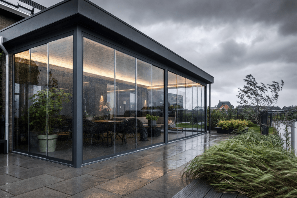 Welke soorten glas en profielen zijn het meest geschikt voor glazen schuifwanden bij veel wind, regen en temperatuurverschillen?